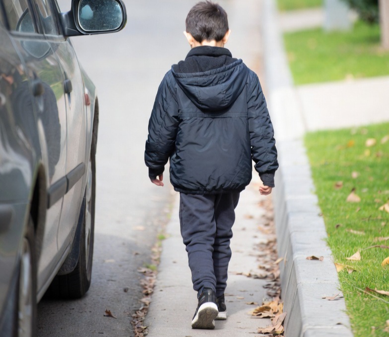 Copil umblând singur pe drum, simbol al consecințelor punitive și al bullying-ului învățat în familie